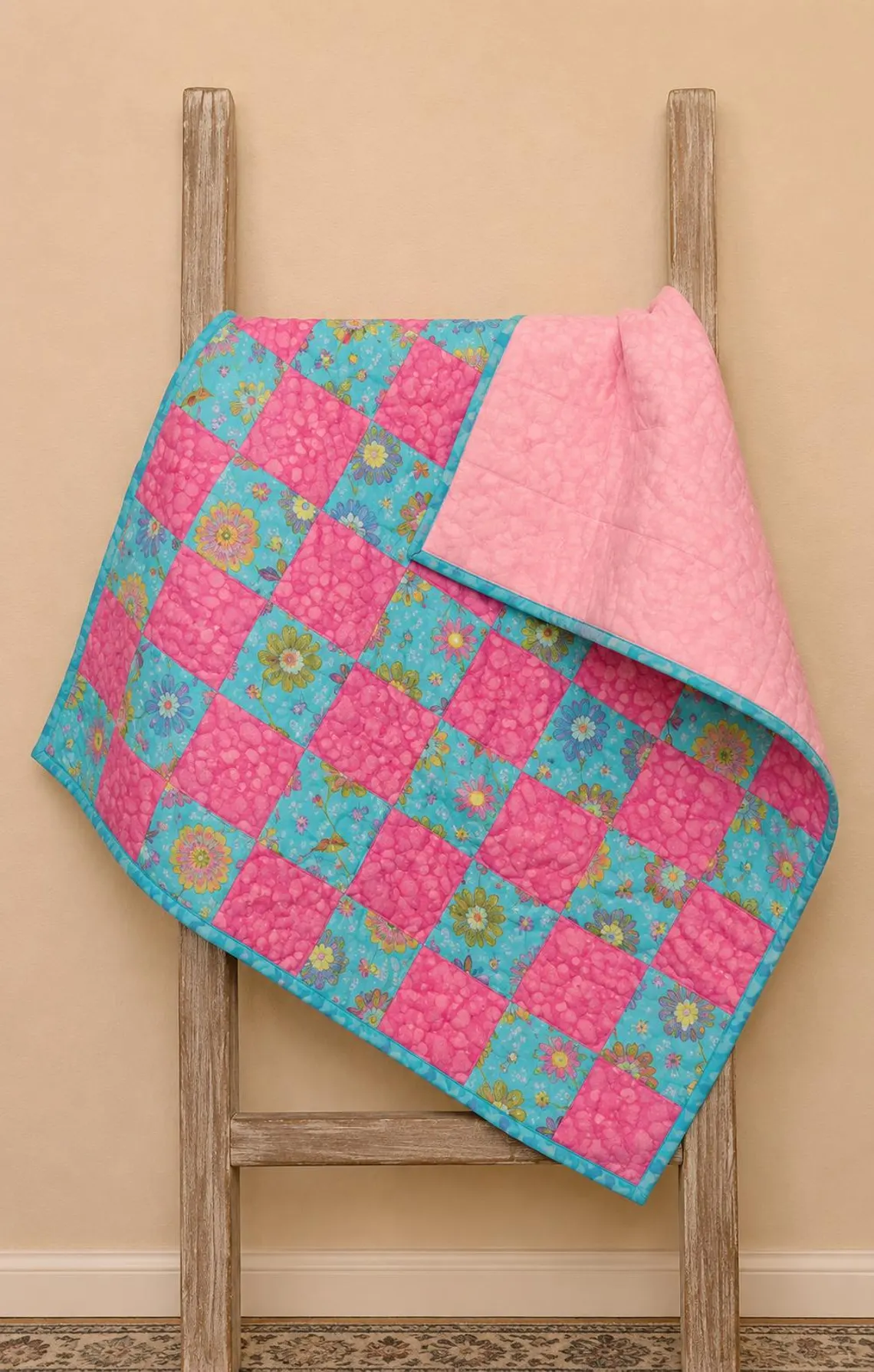 Pink and turquoise floral pieced baby quilt